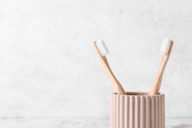 Hafif arka planda ahşap diş fırçaları olan tutucu, yakın plan