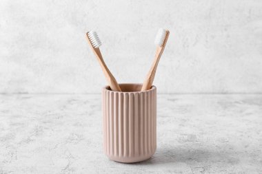 Hafif arka planda ahşap diş fırçaları olan tutucu