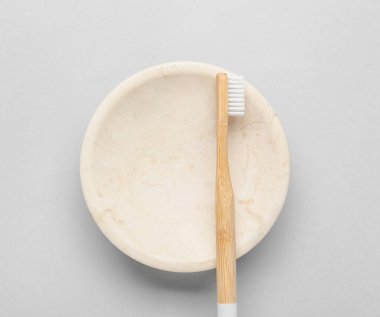 Gri arkaplanda ahşap diş fırçası ve sabun kabı