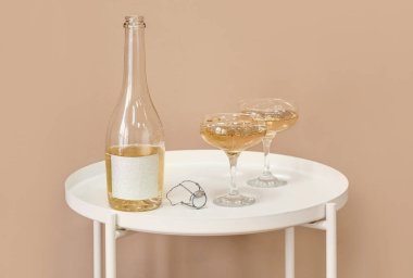 Renkli duvarın yanındaki masada şampanya şişesi ve bardaklar açıldı.