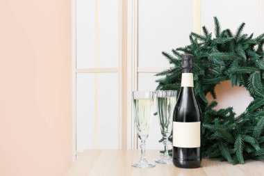 Şişe, şampanya ve Noel çelengi.