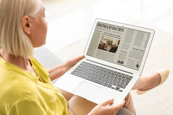 Beautiful Mature Woman Reading Newspaper Laptop Home — Stock Photo, Image