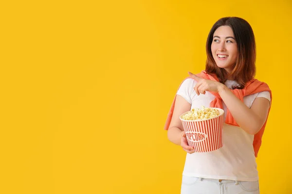Junge Asiatin Mit Leckerem Popcorn Zeigt Auf Etwas Auf Gelbem — Stockfoto