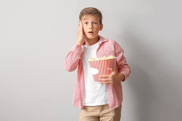 Geschokt Jongetje Met Emmer Lekkere Popcorn Lichte Achtergrond — Stockfoto