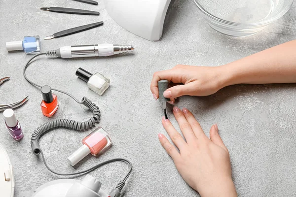 Mujer Joven Aplicando Esmalte Uñas Mesa Luz — Foto de Stock