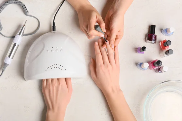 Manicura Maestro Aplicando Esmalte Uñas Mesa Luz — Foto de Stock