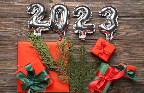 图为2023形状的银球 冷杉树枝和木制背景的圣诞礼物 — 图库照片