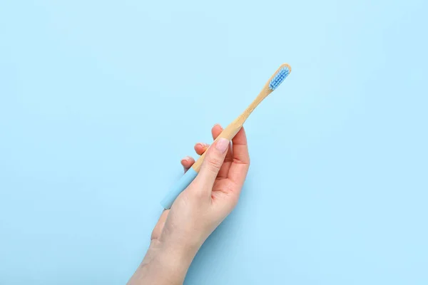 Weibliche Hand Mit Holzzahnbürste Auf Blauem Hintergrund — Stockfoto