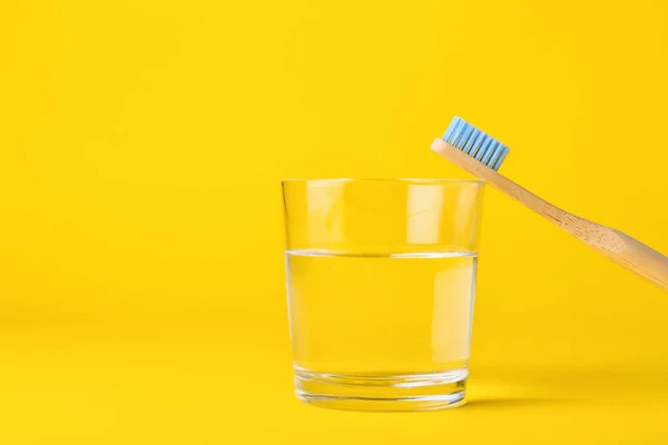 Wooden Toothbrush Glass Water Yellow Background Closeup — Stock Photo, Image