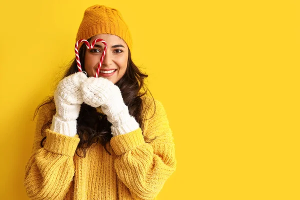 冬服のかわいい若い女性と色の背景にキャンディ缶 — ストック写真