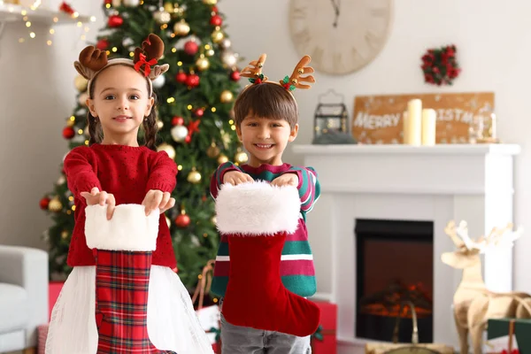 リビングルームでクリスマスソックスとかわいい子供たち — ストック写真