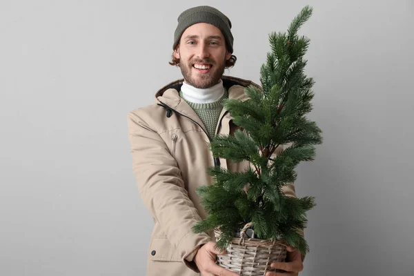 穿着冬衣 背景浅的圣诞树的时髦年轻人 — 图库照片