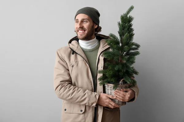 Stilvoller Junger Mann Winterkleidung Und Mit Weihnachtsbaum Auf Hellem Hintergrund — Stockfoto