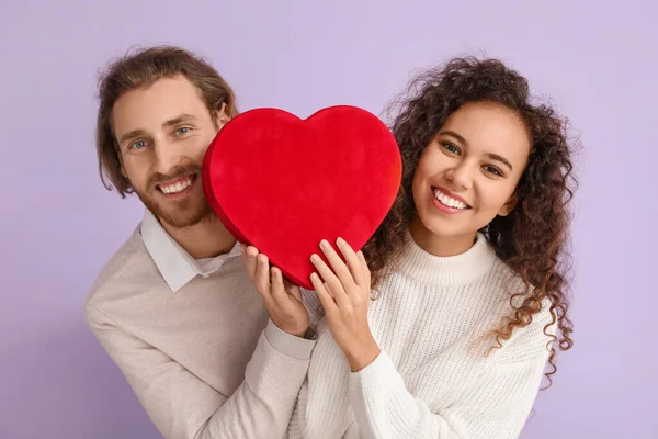 色の背景にギフトボックスを持つ幸せな若いカップル バレンタインデーのお祝い — ストック写真
