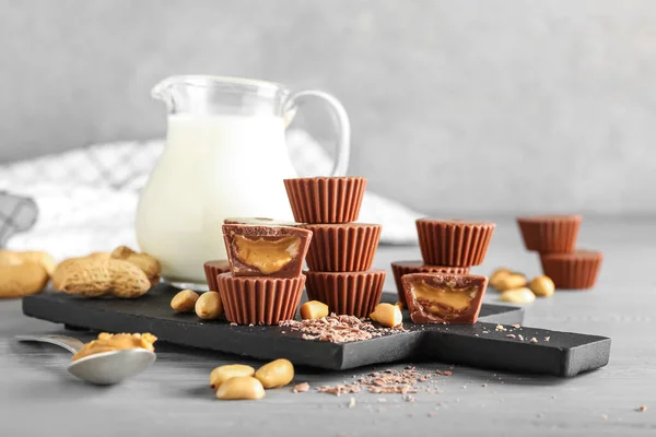 Board Tasty Peanut Butter Cups Jug Milk Table — Stock Photo, Image