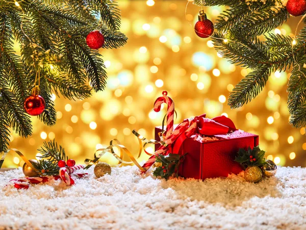 木々の枝やぼやけた光に対する雪とテーブルの上のクリスマスの装飾 — ストック写真