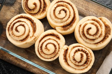 Pişmemiş tarçınlı yemek tabağı ve siyah arkaplan, yakın plan.