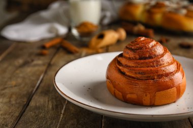 Ahşap zemin üzerinde lezzetli tarçınlı rulo