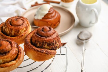 Beyaz ahşap arka planda lezzetli tarçınlı rulo ızgara, yakın plan