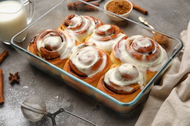 Gri arkaplanda kremalı tarçınlı börek pişirme