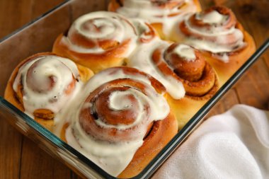 Ahşap arka planda kremalı lezzetli tarçınlı börek pişirme, yakın plan.