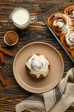 Ahşap arka planda lezzetli tarçınlı tabak ve pişirme tabağı.