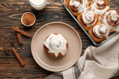 Ahşap arka planda lezzetli tarçınlı tabak ve pişirme tabağı.