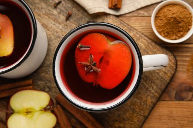 Ahşap arka planda tarçınlı lezzetli elma çayı, yakın plan.