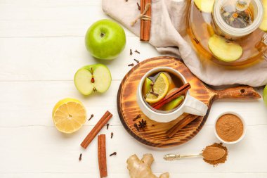 Beyaz ahşap arka planda tarçınlı bir fincan lezzetli meyve çayı.