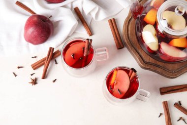 Beyaz arka planda tarçınlı bir bardak lezzetli meyve çayı.