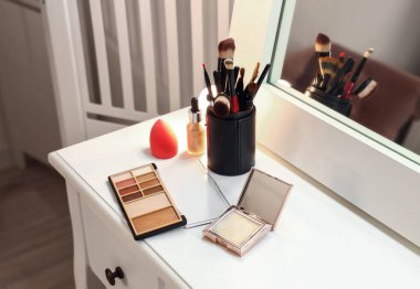 Modern makyaj odasında aynalı giyinme masası.