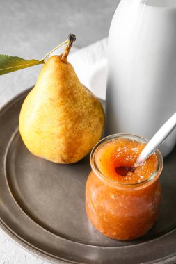 Cam kavanoz armut reçeli ve süt masada, yakın plan.