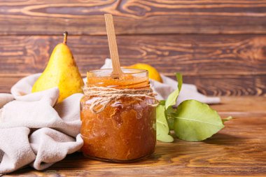 Cam kavanoz armut reçeli ahşap masada.