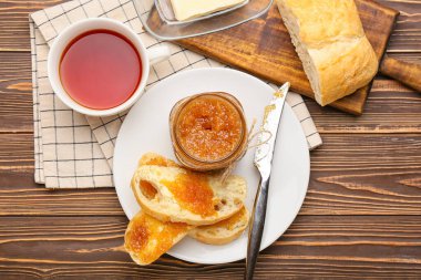 Lezzetli armut reçelli ekmek ve ahşap arka planda bir fincan çay.