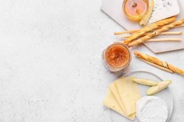 Beyaz arka planda cam kavanoz armut reçeli, peynir ve kraker kompozisyonu