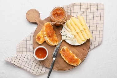 Lezzetli armut reçelli tahta, açık arkaplanda ekmek ve peynir.