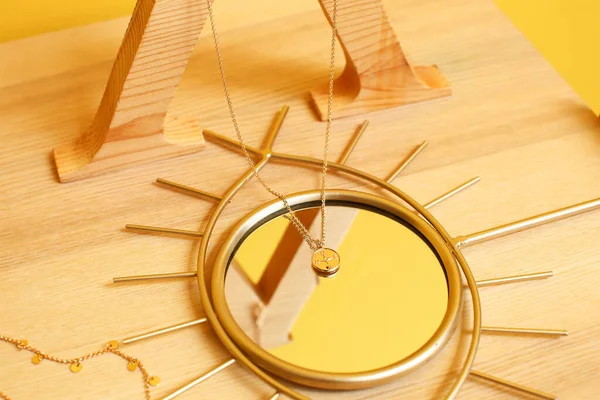 Ayna ve güzel mücevherler ahşap masada.