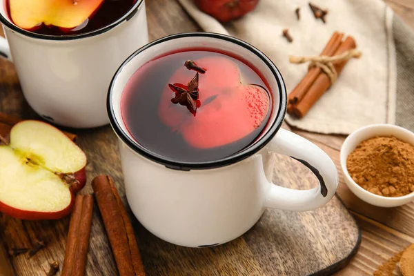 Ahşap arka planda tarçınlı lezzetli elma çayı, yakın plan.