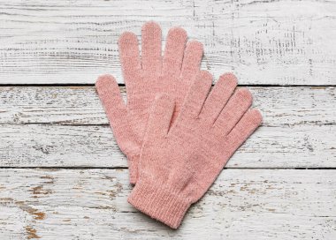 Hafif ahşap arka planda bir çift sıcak eldiven.