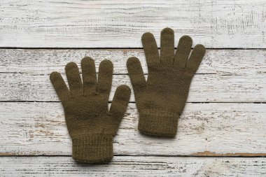 Hafif ahşap arka planda bir çift sıcak eldiven.