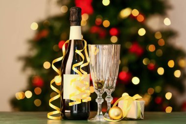 Bulanık arka planda bir şişe şampanya ve Noel süsü.