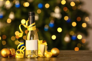Bulanık arka planda Noel dekorlu bir şişe şampanya.