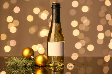Bir şişe şampanya ve Noel dekoru bulanık arka planda.