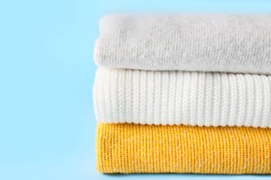 Mavi arka planda yumuşak modern süveter yığını, yakın plan