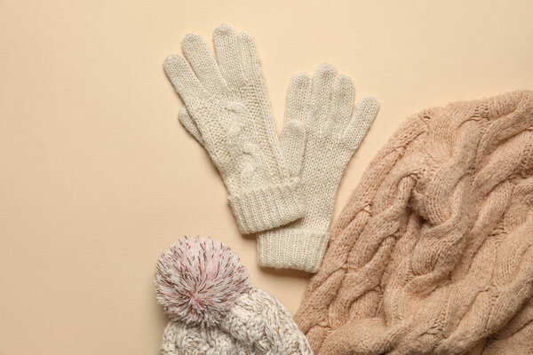 Трикотажные перчатки, шляпа и одежда на цветном фоне, крупный план