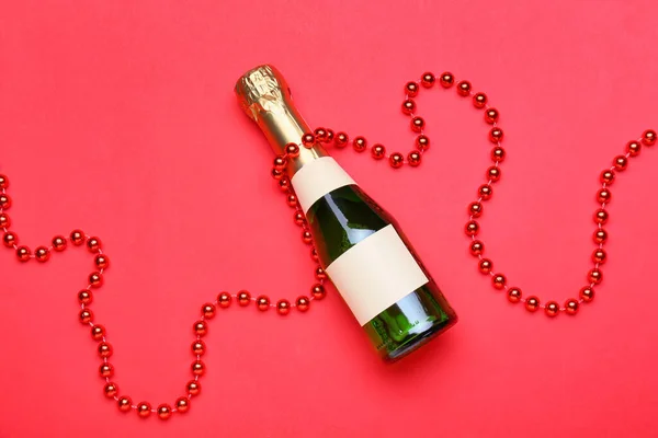 Kırmızı Arka Planda Bir Şişe Şampanya Boncuk — Stok fotoğraf