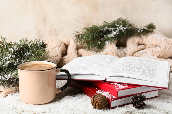 Cup of tasty coffee, book and Christmas decor on light background