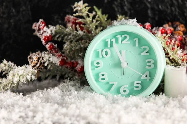 Wecker Und Tannenzweig Auf Schnee Vor Dunklem Hintergrund — Stockfoto