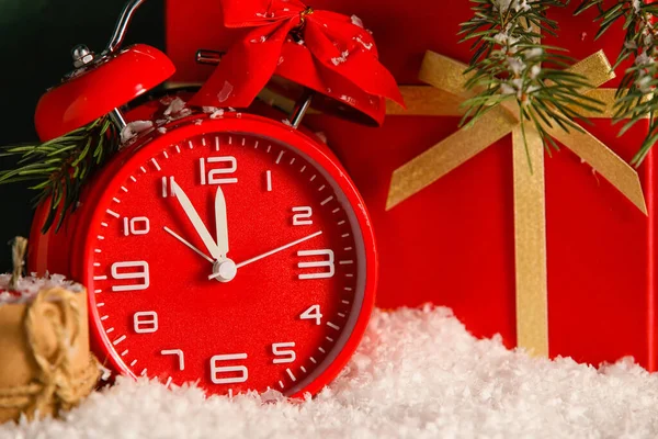 雪の上の目覚まし時計とクリスマスプレゼント — ストック写真