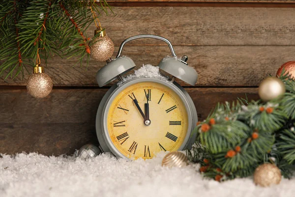 Weihnachtswecker Und Geschmückter Tannenzweig Auf Schnee Vor Holzhintergrund — Stockfoto